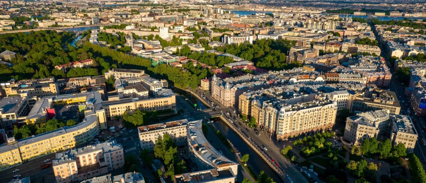 Ilmakuva tiiviistä kaupunkialueesta, jossa näkyy rakennuksia, katuverkkoa ja viheralueita. Kuva havainnollistaa kuntien kestävää kehittämistä ja kaupunkiympäristöä.